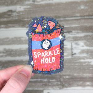 hand holding a sticker printed on sparkle holo laminate sticker paper